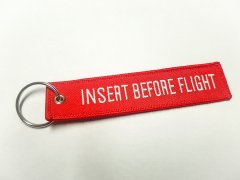 Přívěsek na klíče "Insert before flight"